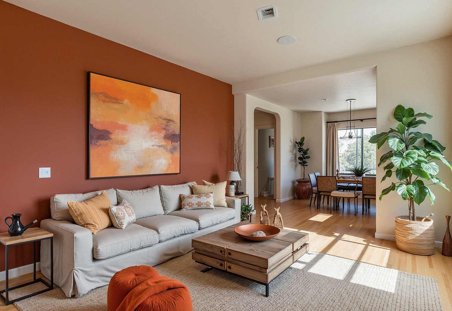 Terracotta accent wall behind a neutral sofa with warm wood and natural decor