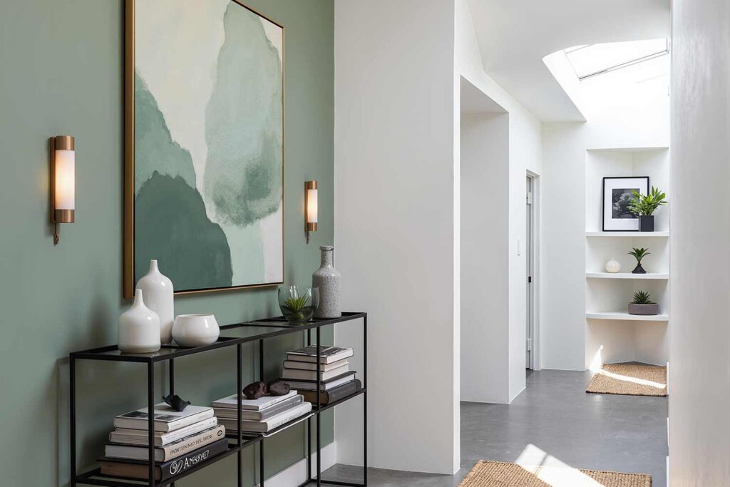 Hallway Gray-Green Walls with White Trim and Polished Concrete Floors, Hallway with Evergreen Fog walls, Pure White trim, light oak floors, botanical décor, and morning sunlight in a Scottsdale Craftsman-style home, hallway painting ideas, hallway paint colors, hallway color schemes, hallway paint combinations, narrow hallway paint ideas, small hallway paint colors, corridor paint designs, entryway color schemes, passageway painting inspiration, foyer paint ideas, hallway color inspiration, corridor decorating concepts, entrance paint solutions, hallway makeover ideas, passage color ideas, vestibule painting concepts, color scheme, paint design, color combination, paint treatment, wall treatment, color palette, paint finish, wall colors, paint selection hallway, color choice, color pairings, color duos, paint matches, color coordination, color harmony, paint partnerships, color marriages, tone combinations, shade pairings, chromatic duets, connecting area, passage space colors, intermediate zone colors, linking space colors, connecting corridor colors, transition zone colors, thoroughfare colors, connecting pathway colors, interim space colors, passage area colors, refined, elegant, polished, upscale, distinguished painter, cultivated, tasteful, luxurious, elevated, high-end painting