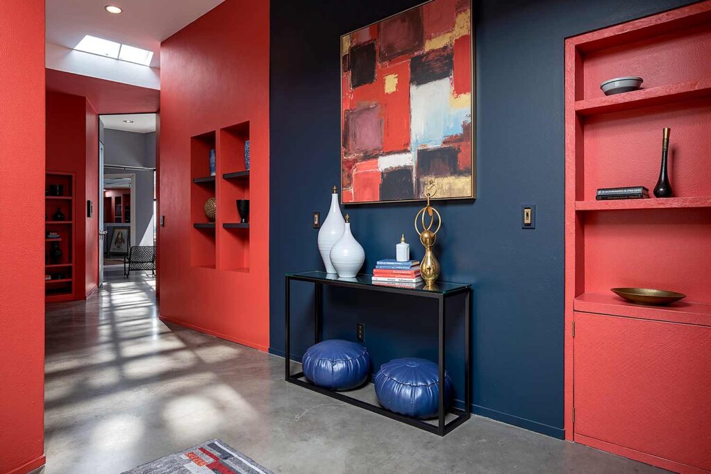 Navy Blue Accent Wall in Hallway with Red Walls and Polished Concrete Floors, Industrial hallway with Naval accent wall, Heartthrob red surroundings, polished concrete floors, and midday sunlight in a Scottsdale home, hallway painting ideas, hallway paint colors, hallway color schemes, hallway paint combinations, narrow hallway paint ideas, small hallway paint colors, corridor paint designs, entryway color schemes, passageway painting inspiration, foyer paint ideas, hallway color inspiration, corridor decorating concepts, entrance paint solutions, hallway makeover ideas, passage color ideas, vestibule painting concepts, color scheme, paint design, color combination, paint treatment, wall treatment, color palette, paint finish, wall colors, paint selection hallway, color choice, color pairings, color duos, paint matches, color coordination, color harmony, paint partnerships, color marriages, tone combinations, shade pairings, chromatic duets, connecting area, passage space colors, intermediate zone colors, linking space colors, connecting corridor colors, transition zone colors, thoroughfare colors, connecting pathway colors, interim space colors, passage area colors, refined, elegant, polished, upscale, distinguished painter, cultivated, tasteful, luxurious, elevated, high-end painting
