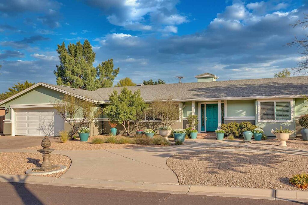 Ranch-Style Home with Sage Green Upper Walls Stone Gray Lower Walls White Trim Teal Door, ranch house color scheme, ranch house colors, Exterior color ideas, House painting inspiration, Two-tone color scheme, Ranch architecture, ranch style, ranch home, ranch silhouette, Color combination, color palette, color pairing, color expression, Exterior Facade, outdoor, outside surface, exterior walls, Modern, Contemporary, current, updated, fresh, Transformation, Makeover, reimagining, updating, refreshing,