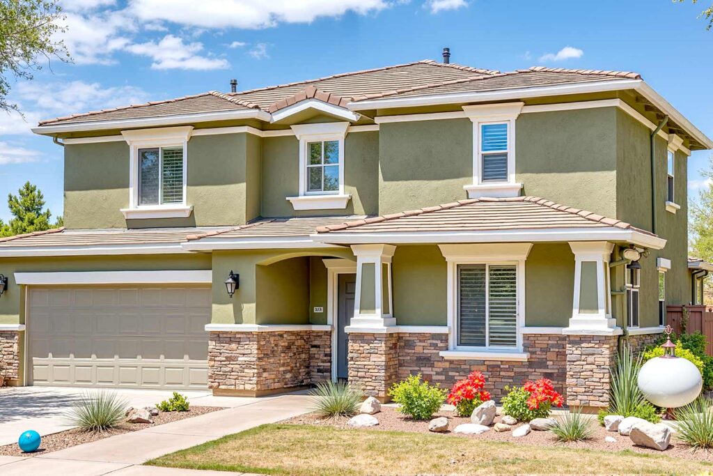 Large craftsman-inspired house with a two-car garage in a Scottsdale neighborhood, recently painted olive green with white trim and stone accents. Features a gray garage door, slate gray front door, lush landscaping, oversized bronze sphere sculpture, and a dirty, stained driveway in dynamic late afternoon light. cream and green house in Phoenix, affordable exterior painting contractors, best exterior home painting contractors, Transform Your Home's Curb Appeal with one of the Best Exterior Painting Contractors in Phoenix, best exterior painting contractors, exterior painting contractor near me, exterior painting contractors near me, exterior paint contractor near me, exterior paint contractors near me, exterior painting company near me, exterior house painting contractors, exterior home painting contractors, exterior painting contractor, exterior painting contractors, exterior paint contractors, Phoenix, Scottsdale, Arcadia