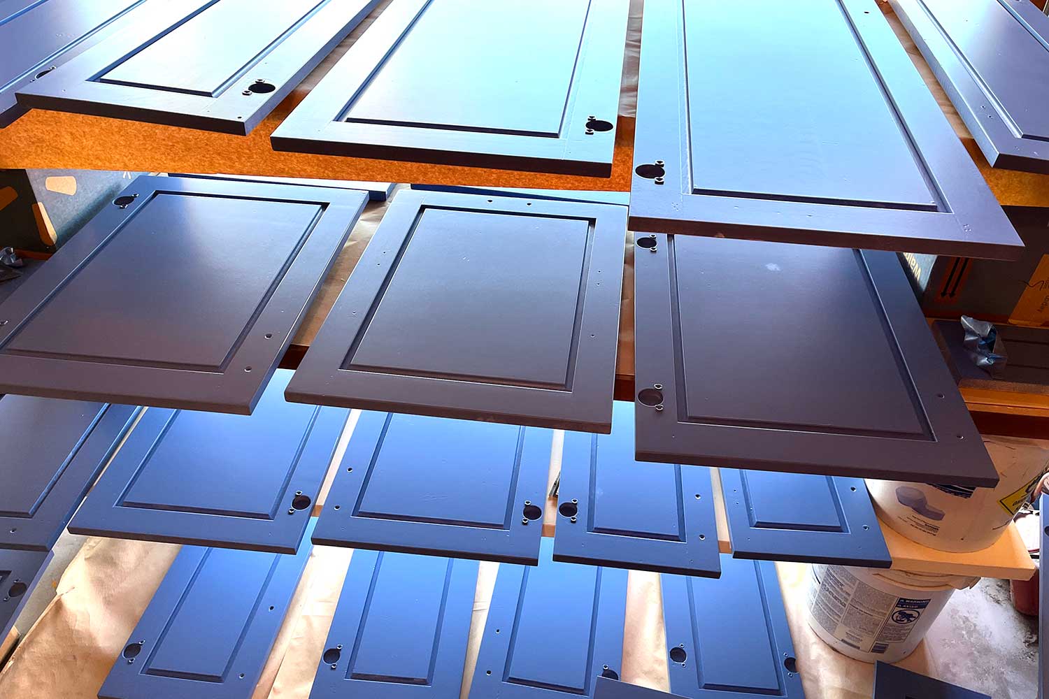 kitchen cabinet doors being painted on drying rack, the paint is blue, blue kitchen cabinets doors drying white being painted, refinishing kitchen cabinets, cabinet painting, repainting kitchen cabinets, updating kitchen cabinets, kitchen cabinet makeover, kitchen cabinet refinishing, painting cupboard doors, kitchen cabinet resurfacing, kitchen cabinet restoration, painting wood cabinets, kitchen cabinet re-coating, painting cabinet doors, kitchen cabinet color change, kitchen cabinet sprucing, kitchen cabinet transformation, painting kitchen cabinets, how to paint kitchen cabinets Bryce House Painting