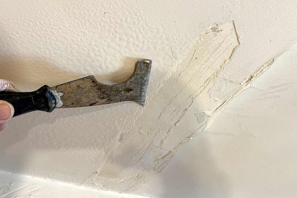 Scraping Away Loose, Flaking Paint, Hand scraping away flaking paint highlights typical exterior paint problems, like poor adhesion and weather damage. Does my house need to be painted? If your walls require this much prep, it’s a sign your old paint has failed and your home needs a durable, new coat, , house still looks dirty after cleaning, why is my house still dirty after washing, house not clean after power washing, exterior still dirty after wash, why doesn’t my house look clean after washing