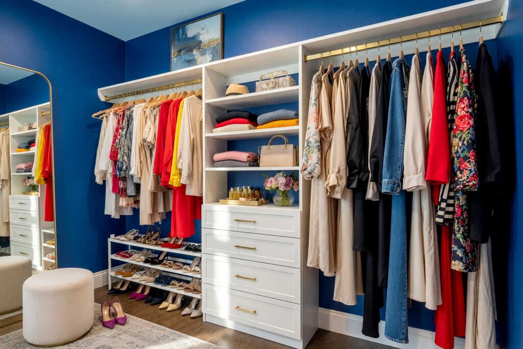 Walk-in Closet with Blue Walls and Sky Blue Ceiling and Warm White Cabinetry-2, luxurious walk-in closet with sapphire blue walls pale sky blue ceiling warm white cabinetry and walnut floors Scottsdale neighborhood luxurious walk-in closet with sapphire blue walls pale sky blue ceiling warm white cabinetry and walnut floors boutique-inspired design in a Scottsdale neighborhood sunlight casting dramatic shadows, boutique closet color ideas, wardrobe room painting inspiration, closet decorating color ideas, luxury closet color ideas, custom closet paint colors, walk-in closet design colors, dressing room design inspiration, closet wall paint inspiration