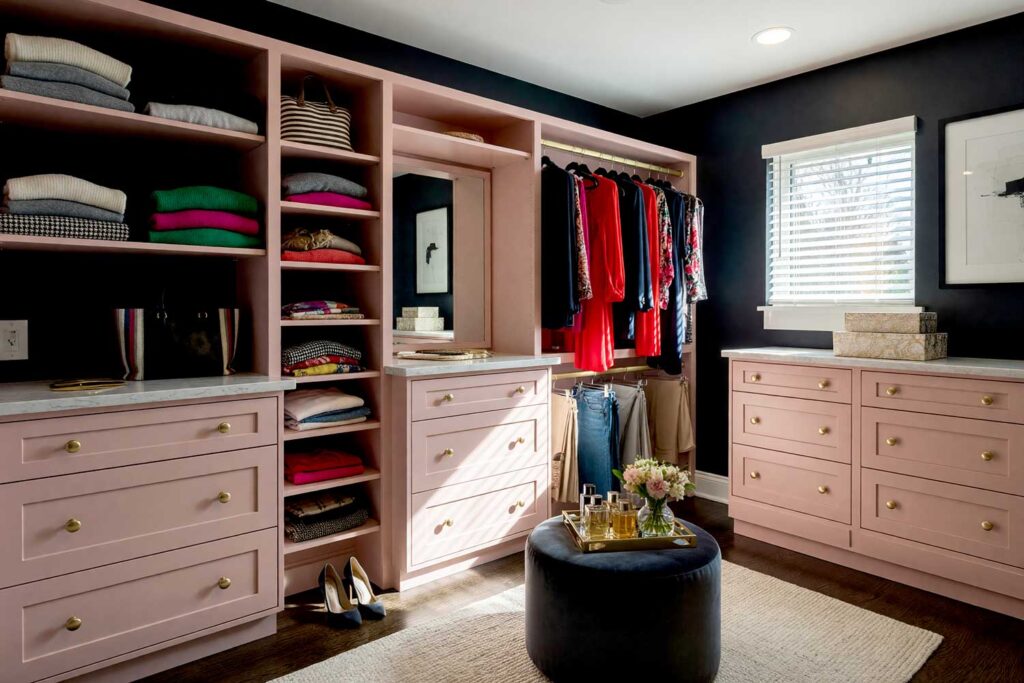 Walk-in Closet with Charcoal-Black Walls White Ceiling and Dusty Pink Cabinetry-3, bold walk-in closet with charcoal-black walls warm white ceiling dusty blush pink cabinetry and dark oak floors Scottsdale neighborhood bold walk-in closet with charcoal-black walls warm white ceiling dusty blush pink cabinetry and dark oak floors editorial-inspired design in a Scottsdale neighborhood sunlight casting dramatic shadows, boutique closet color ideas, wardrobe room painting inspiration, closet decorating color ideas, luxury closet color ideas, custom closet paint colors, walk-in closet design colors, dressing room design inspiration, closet wall paint inspiration