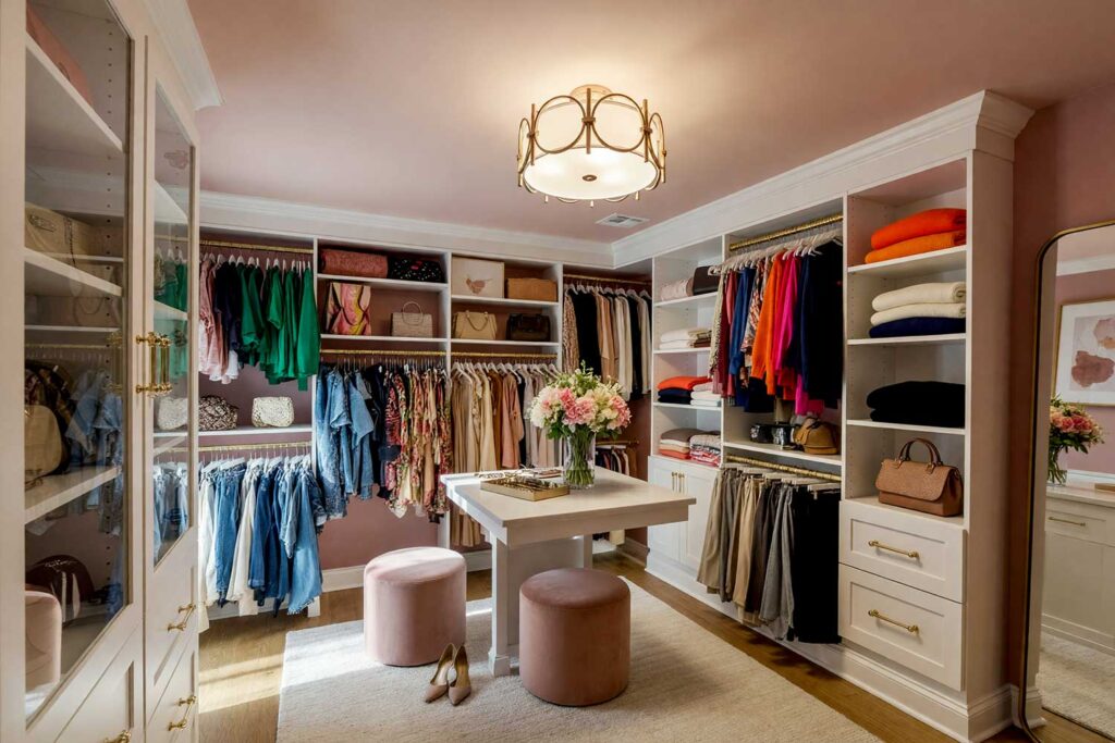 Walk-in Closet with Dusty Rose Walls Blush Ceiling and White Cabinets-3, luxurious walk-in closet with dusty rose walls pale blush ceiling warm white cabinetry and light oak floors Scottsdale neighborhood luxurious walk-in closet with dusty rose walls pale blush ceiling warm white cabinetry and light oak floors boutique-inspired design in a Scottsdale neighborhood sunlight casting dramatic shadows, dressing room paint colors, boutique dressing room colors, closet color schemes, closet wall color ideas, closet paint colors, closet color palettes, wardrobe room color ideas, closet design color inspiration, closet paint color inspiration, dressing room paint ideas