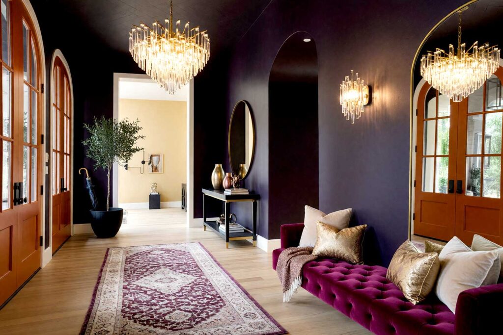 Moody Sophisticate Foyer with Midnight Plum Walls and Burnt Copper Door-3, moody sophisticated foyer featuring midnight plum walls burnt copper door antique ivory trim and deep charcoal ceiling in a freshly painted Scottsdale neighborhood home. luxurious decor includes metallic vases brass accents and a plush area rug illuminated by strong morning sunlight casting dramatic shadows and bright highlights for a bold and theatrical entrance, bold foyer paint colors, foyer paint color ideas, entryway paint colors, bold interior color choices, interior color choices, dark entryway colors, dark foyer colors, dark tones, moody entryway