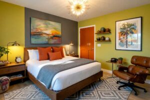 Vibrant Palm Springs Modernist Guest Bedroom with Iconic Mid-Century Décor-3-FEATURE, vibrant palm springs modernist guest bedroom chartreuse walls smoke gray accent wall burnt orange door mid-century modern décor light oak flooring strong natural light casting angular shadows, guest bedroom paint colors, bedroom paint palette, guest room color palette, guest bedroom paint idea, guest bedroom paint ideas, guest room color idea, interior bedroom paint palette, guest room paint scheme, bedroom color scheme, guest suite paint colors, room paint ideas for guests, bedroom color inspiration