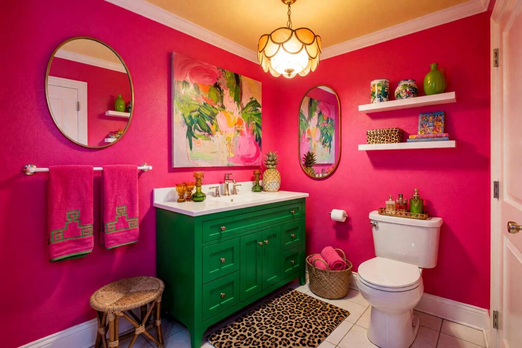 Palm Beach Powder Room with Hot Pink Walls Kelly Green Cabinet Yellow Ceiling and White Trim-1, palm beach maximalist powder room hot pink walls kelly green cabinet pale yellow ceiling bright white trim brass chandelier leopard print bath mat. A lively and confident powder room in a Scottsdale neighborhood featuring hot pink walls and a vibrant kelly green vanity with brass hardware. The scalloped brass chandelier and leopard-print bath mat add playful glamour, while rattan furniture and tropical-inspired accessories complete the maximalist aesthetic. Dynamic lighting highlights the bold colors, creating an energizing and luxurious atmosphere. powder room paint ideas, powder room paint colors, powder room color inspiration, half bath paint ideas, bathroom color ideas, powder room color ideas, small bathroom paint ideas, powder room color schemes, guest bathroom paint ideas