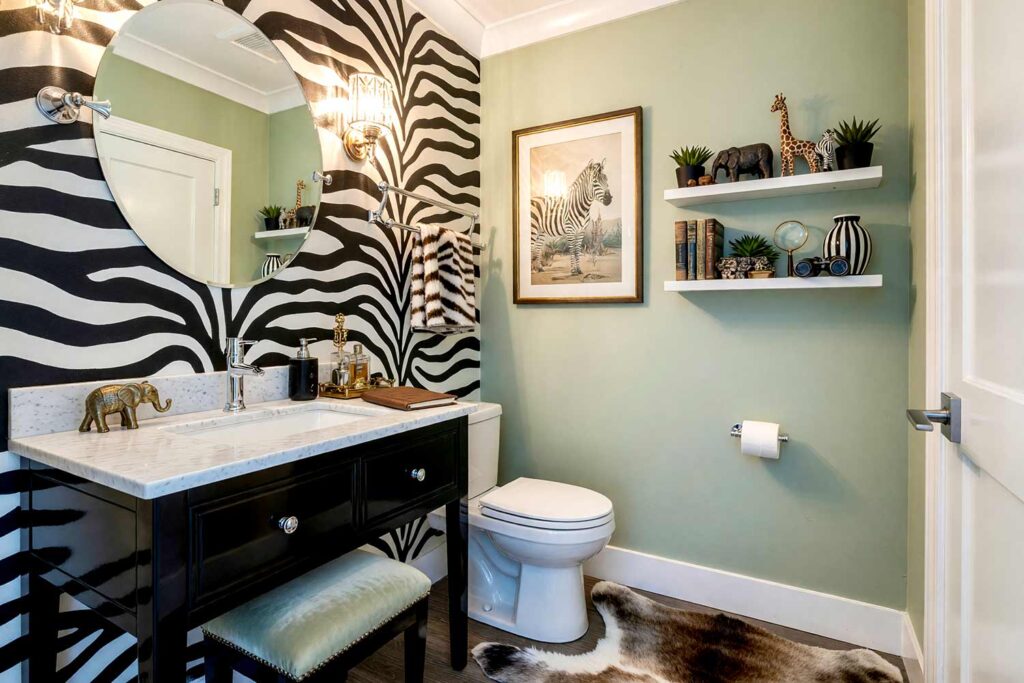 Powder Room with Black and White Zebra Striped Accent Wall and Pale Sage Walls-5, glitz and glam powder room uneven black and white zebra striped accent wall pale sage walls bright white ceiling trim black lacquer vanity. A bold Scottsdale neighborhood powder room featuring hand-drawn zebra stripes, a sleek black lacquer vanity, and a faux fur zebra-skin rug. Crystal sconces cast warm flickering light, highlighting wild pattern and sophisticated calm. The pale sage walls balance the drama, creating a glamorous retreat where every guest lingers longer. painting striped walls, painting wall stripes, painted wall stripes, two tone striped walls, painting striped accent walls, striped wall paint ideas, painted stripe walls