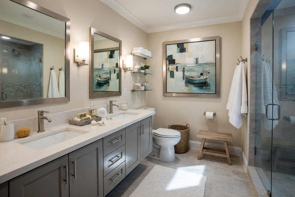 Coastal Contemporary Bathroom with Almond Walls and Slate Gray Vanity-6, coastal contemporary bathroom neutral interior paint colors almond walls slate gray vanity cloud white trim limestone flooring. A boutique spa retreat in a Scottsdale neighborhood featuring a slate gray floating vanity, limestone tile floors, brushed nickel sconces, and a seagrass hamper. Decorated with a coastal cubist artwork, plush waffle-weave textiles, and steam-fogged glass. Vibrant directional morning daylight creates sharp contrast across the serene neutral surfaces. neutral tones for interiors, neutral wall paint colors, muted neutral colors, soft neutral color palette, interior neutral color palette