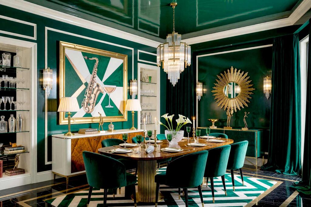 Art Deco Dining Room with Emerald Green Walls and Ivory Trim-3, art deco dining room emerald green walls ivory trim ceiling high gloss interior paint black marble floors. A glamorous Art Deco jewel-box dining room in an upscale Scottsdale neighborhood pairing glossy emerald green walls and ceiling with tuxedo-inspired ivory trim. Styled with a burled walnut dining table, emerald velvet chairs, a sunburst mirror, fluted glass chandelier, and polished black marble flooring. Dynamic directional lighting creates stark highlights and deep shadows across reflective surfaces, setting the stage for unforgettable, high-society dinner entertaining.