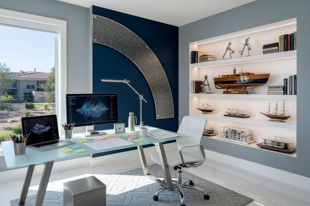 High-Tech Home Office with Gray Walls and Perforated Zinc Mesh Arc-3, high-tech home office mist gray walls maritime navy arc perforated zinc mesh frost white baseboards porcelain floors painting creative wall treatments. A futuristic command studio in a Scottsdale neighborhood featuring a glass-topped desk, a powered-on laptop with messy notes, floating perforated zinc mesh, and a detailed half-hull ship model. Strong sunlight projects pinhole patterns through the metal panel, accentuating the shiny frost white woodwork and mission-control aesthetic. painting creative wall treatments, creative wall treatments, mixed material wall treatments, dimensional painted walls, textured accent wall ideas, metal accent wall ideas