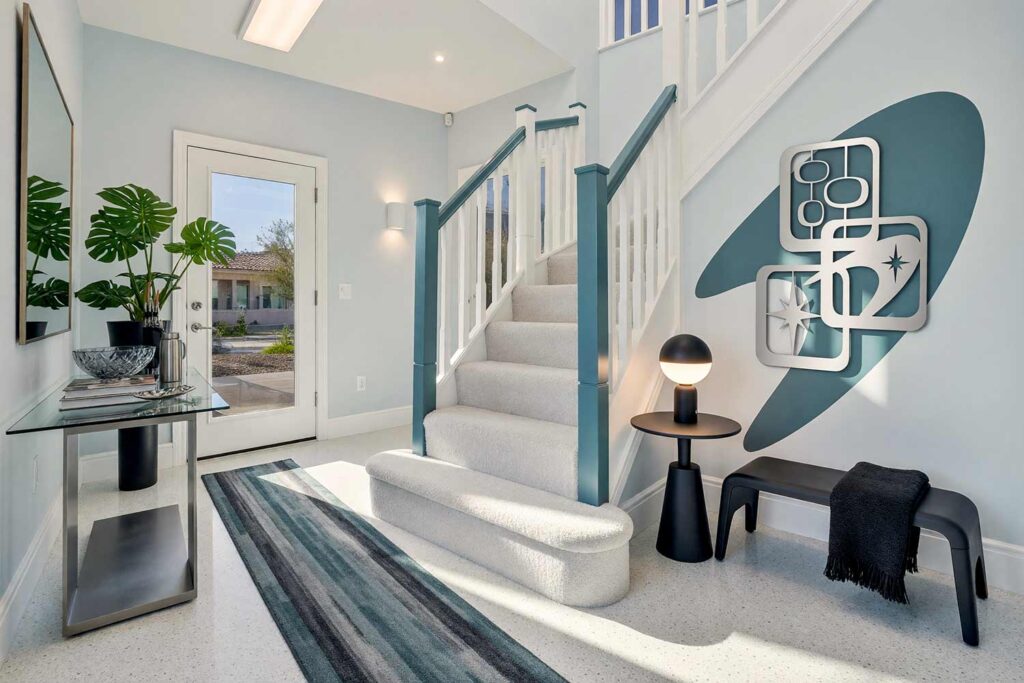Entryway with Pale Fog Blue Walls Slate and Teal Accent and Wall Sculpture-7, modern sci-fi hallway pale fog blue walls slate teal accent panel painting for wall sculptures frost white trim pale gray floor. An aspirational gallery hallway in a Scottsdale neighborhood showcasing a brushed silver retro-atomic sculpture backed by a sweeping slate teal painted boomerang. Featuring a smoked-glass console, dark charcoal bistro table, a vibrant leafy plant, and a glowing black sphere lamp, the corridor delivers dramatic command-deck sophistication. painting for wall sculptures, metal wall art paint ideas, paint backdrop for metal wall hanging, extending wall art with paint, painting behind wall sculptures, paint ideas for metal wall art, wall color for metal wall sculptures, accent wall paint for metal art