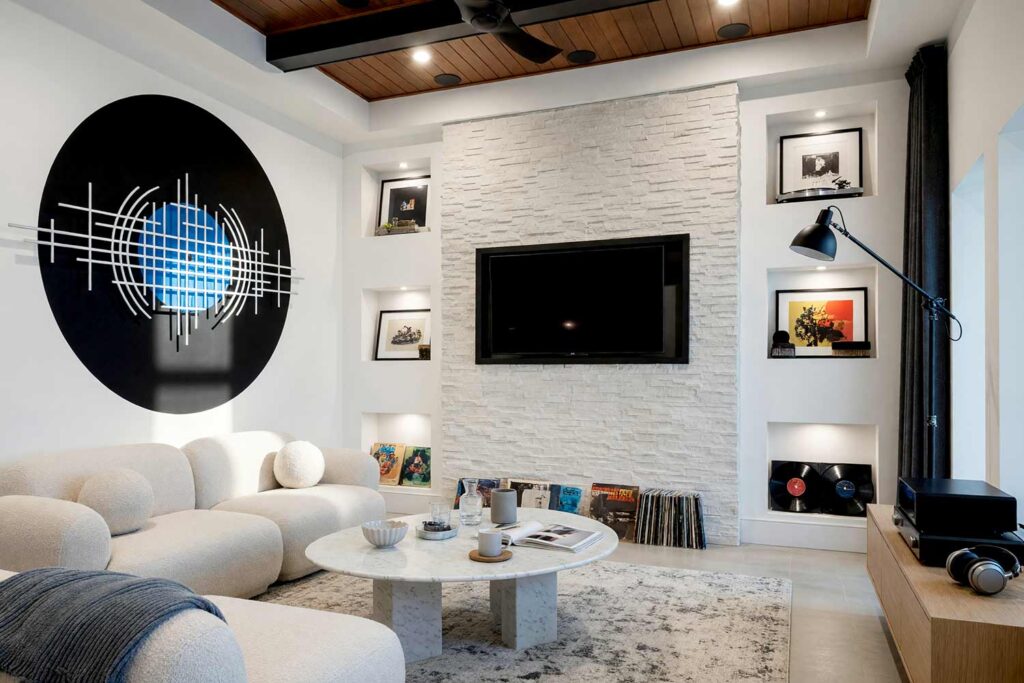 Music Lounge with White Walls and Black Accent and Wall Sculpture-5, modern vinyl lounge chalk white walls jet black record circle painting for wall sculptures light pearl gray trim concrete floor. A high-fidelity retreat in a Scottsdale neighborhood featuring a white sound wave wall sculpture mounted across a painted jet black vinyl record with a cobalt blue label. Styled with a cream bouclé sofa, organic marble coffee table, stacked vinyl albums, and polished concrete, this listening sanctuary unites audiophile culture with luxury design. painting for wall sculptures, metal wall art paint ideas, paint backdrop for metal wall hanging, extending wall art with paint, painting behind wall sculptures, paint ideas for metal wall art, wall color for metal wall sculptures, accent wall paint for metal art