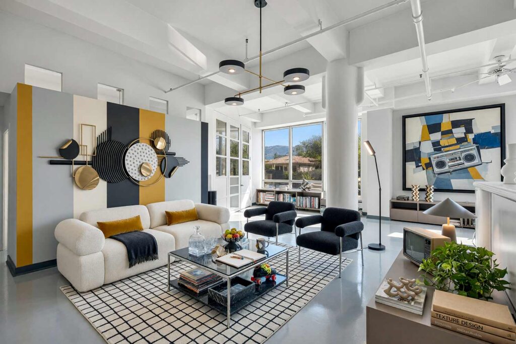 Post-Modern 1980s Gallery Loft with Light Gray Walls Striped Color Bands and Wall Sculpture-4, post-modern 1980s gallery loft living room light gray walls cream charcoal dark mustard yellow stripes soft white ceiling dark gray trim concrete flooring painting for wall sculptures. An expansive 1980s-inspired loft in a Scottsdale neighborhood featuring a cream bouclé modular sofa, taupe-mocha console, oversized texture design books, and polished concrete floors. A five-band painted stripe treatment in cream, charcoal, and dark mustard yellow frames a 3D metal disc sculpture. Direct natural daylight and gallery spotlights cut sharp shadows across shiny dark gray woodwork. paint treatments for metal wall hangings, painted wall graphics for metal art, wall paint design behind metal sculpture, creative paint ideas for wall sculptures, painting an accent wall behind wall art, painted backdrop for wall sculpture