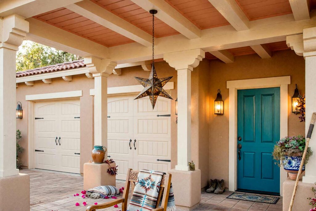 Southwest Porch Ceiling with Blush Terracotta Ceiling Cream Pillars and Turquoise Door-1, covered patio ceiling paint blush terracotta southwestern hacienda sand beige stucco deep turquoise door. Situated at an exclusive Scottsdale estate, this Southwestern porch showcases a semi-gloss blush terracotta ceiling framed by cream pillars and matte sand beige stucco. A Moravian star lantern, Talavera pottery, and a deep turquoise door evoke vibrant desert romance. Dynamic late-afternoon lighting casts dramatic shadows across the woodwork. porch ceiling ideas, painted porch ceiling ideas, haint blue porch ceiling, front porch ceiling paint colors, covered patio ceiling paint, blue porch ceiling, haint blue paint colors